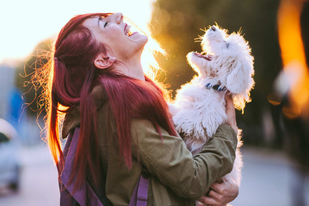 Resident and her dog howling happily outside their new home at The Lodge on the Chattahoochee Apartments in Sandy Springs, Georgia
