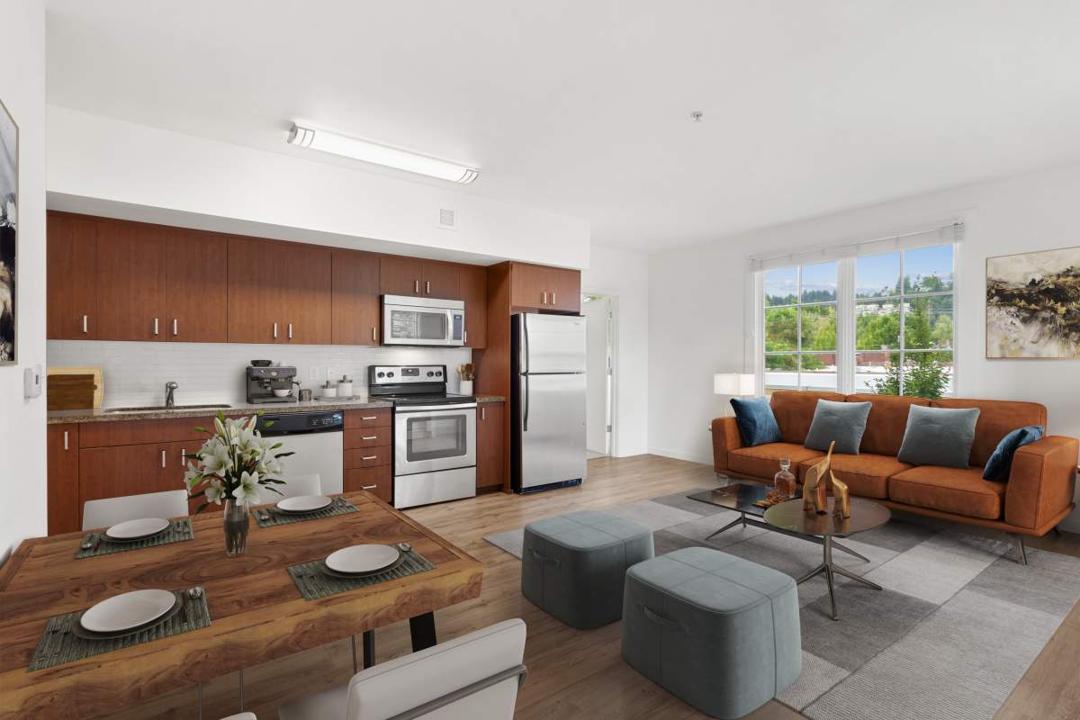 Apartment kitchen and living room with wood-style flooring at The Cordelia in Portland, Oregon