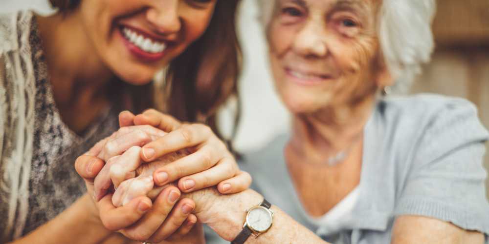 A resident and daughter holding hands at Careage at Home in Bellevue, Washington. 