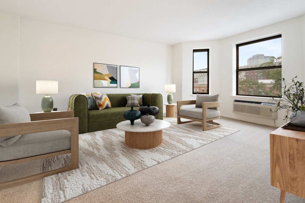 Carpeted living room with bay windows at The Brunswick in New Brunswick, New Jersey