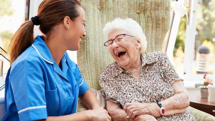 Caregiver sharing a joyful moment with a senior resident at The Landing at Stone Oak in San Antonio, TX, highlighting compassionate and connected care.
