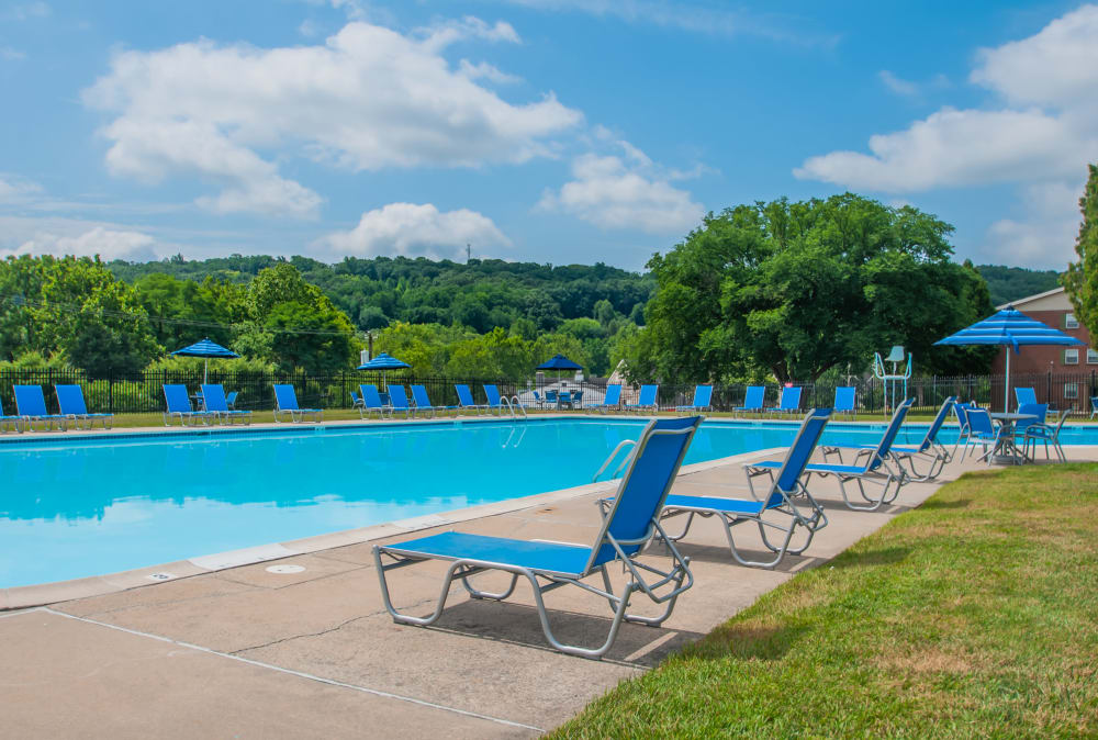 Swimming pool surrounded by lounge chairs at Kingswood Apartments & Townhomes in King of Prussia, Pennsylvania