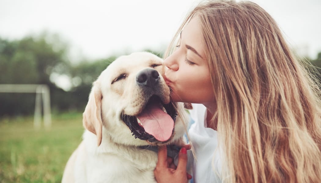 Resident kissing her pup at a park near Preserve at Cradlerock Apartment Homes in Columbia, Maryland