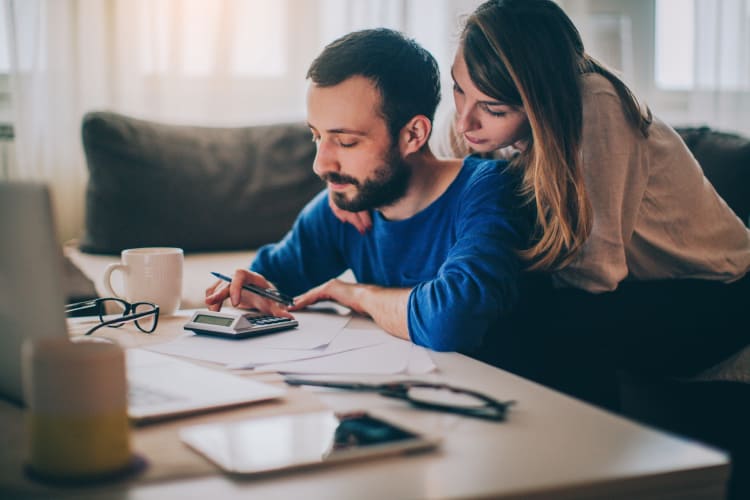 Couple at desk with a calculator at Riverwood Commons