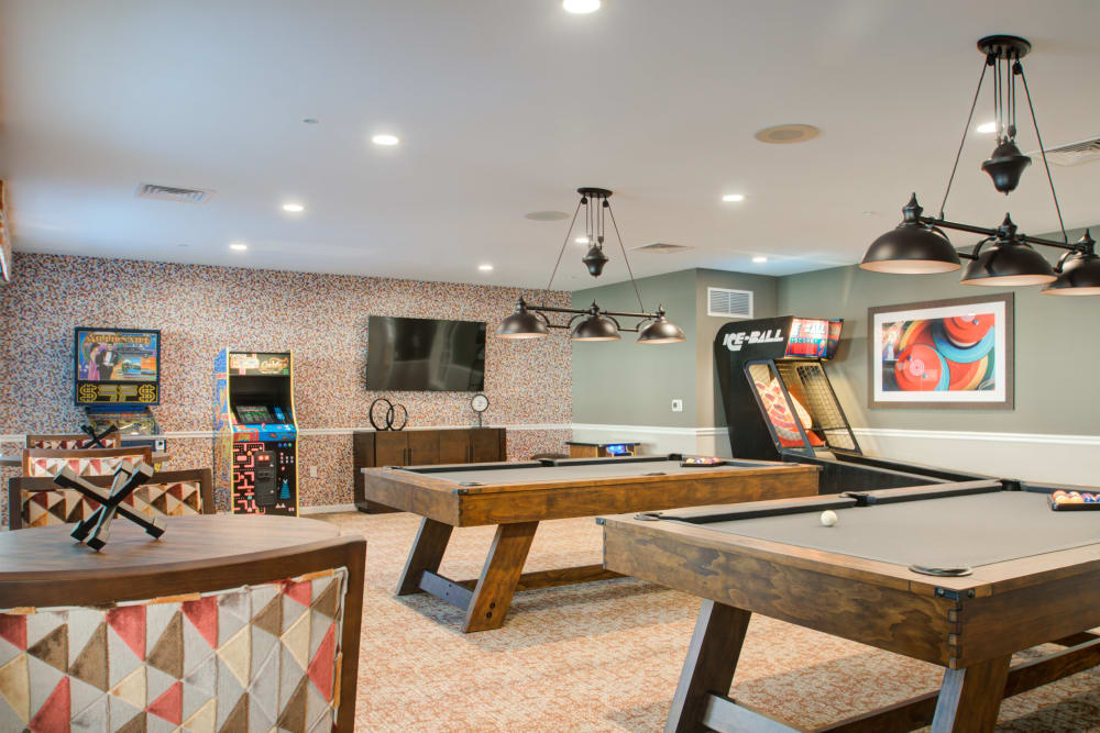 Game room with skee-ball, arcade cabinets, and pool tables at Crescent Fields at Huntingdon Valley in Huntingdon Valley, Pennsylvania