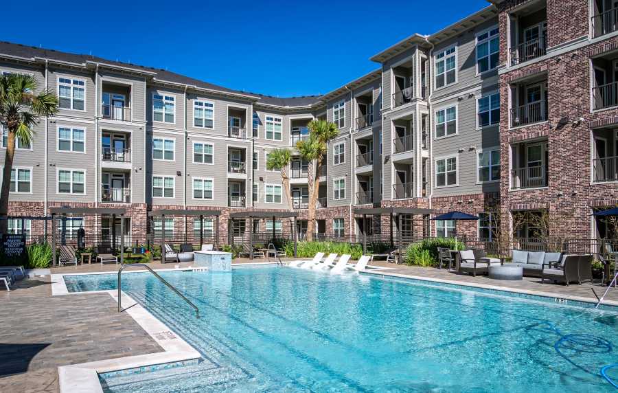 Large outdoor swimming pool with clear blue water at Charleston at Fannin Station in Houston, Texas