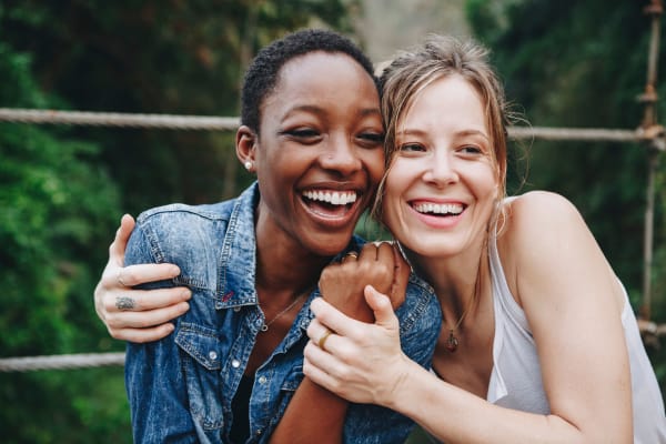 Two smiling women embracing outside near The Alexandria in Madison, Alabama