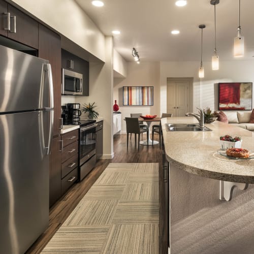 Gourmet kitchen with an island and granite countertops in a model home at Vistara at SanTan Village in Gilbert, Arizona