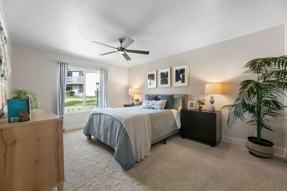 Spacious bedroom with ceiling fan and large window at Sofi Laguna Hills in Laguna Hills, California