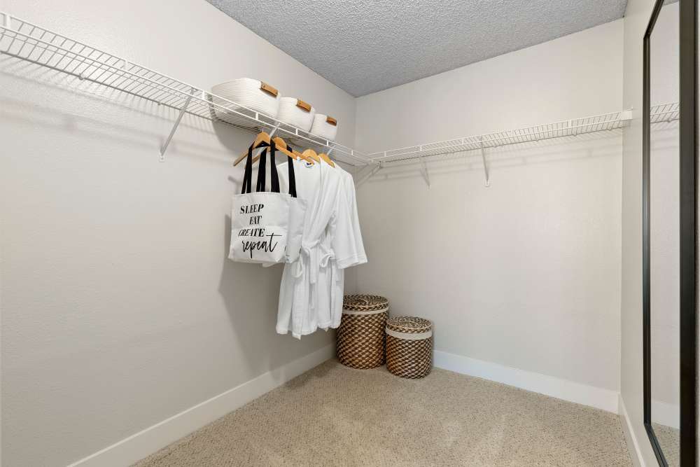 Spacious closet with hanging robes, storage baskets, and shelves at Sofi Laguna Hills in Laguna Hills, California
