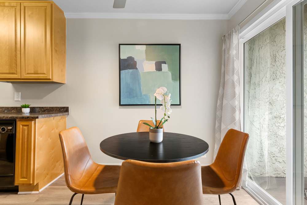 Modern dining area with a round table, stylish chairs, and artwork at Sofi Laguna Hills in Laguna Hills, California