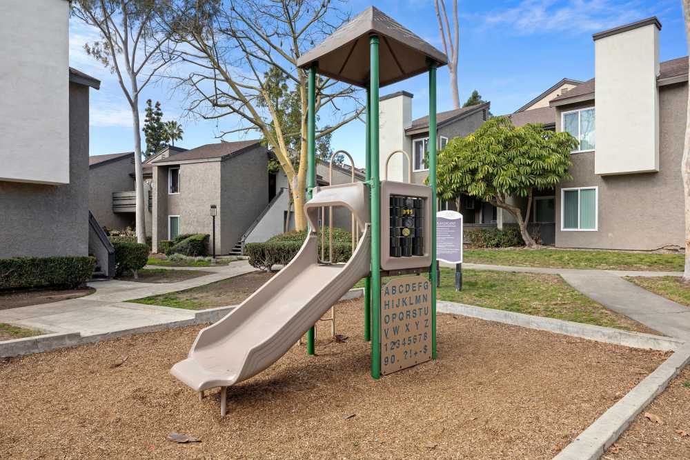 Children's playground featuring a slide and educational panel at Sofi Laguna Hills in Laguna Hills, California