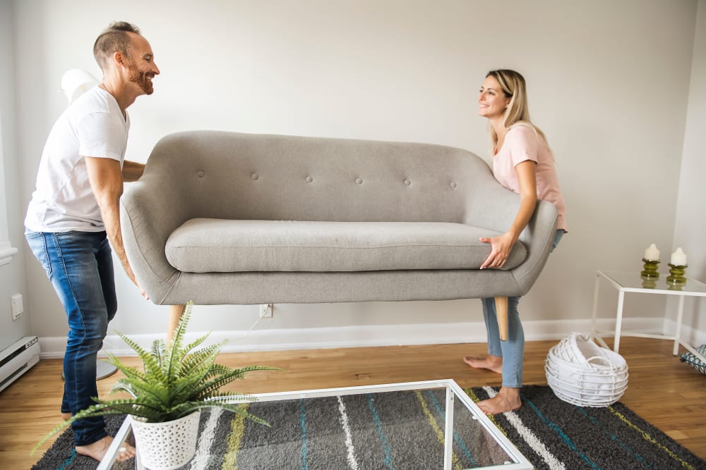 Couple moving a couch in preparation for storage in Murfreesboro, Tennessee at Secure Storage