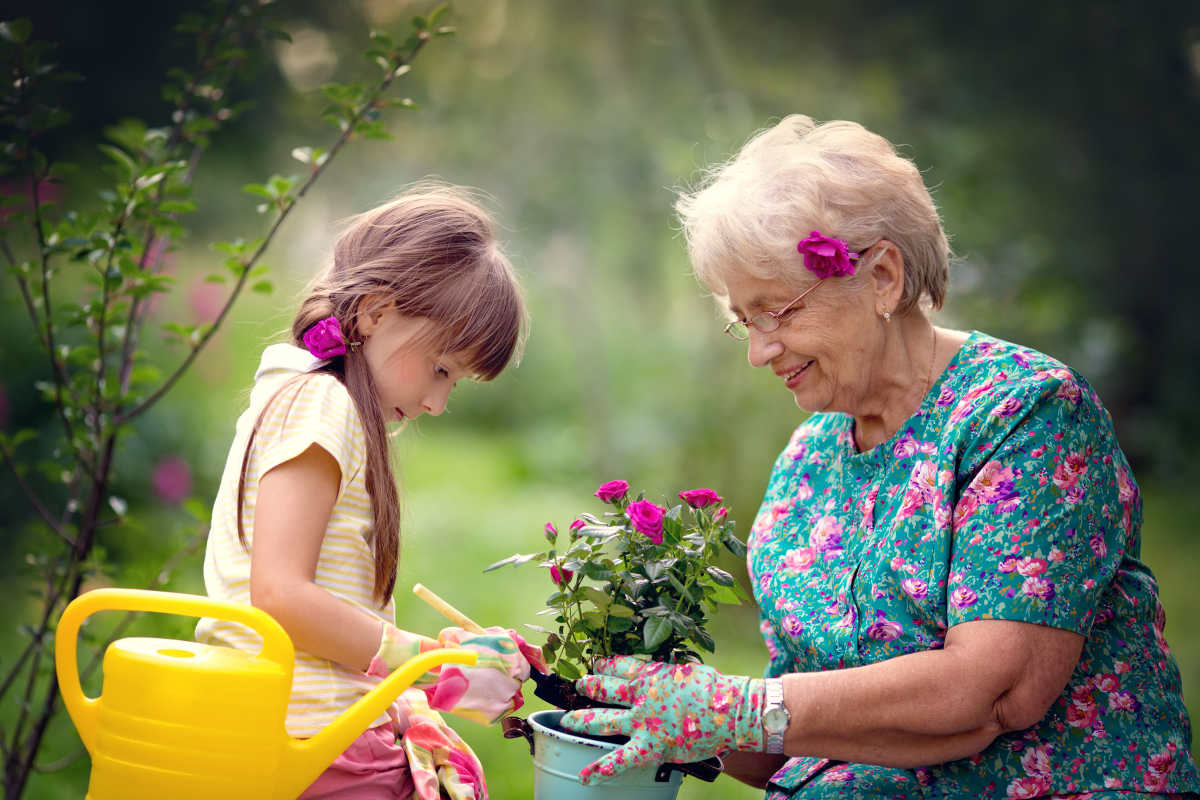 A resident and a small child planting flowers at Keystone Place at Beachwalk in Fort Myers, Florida