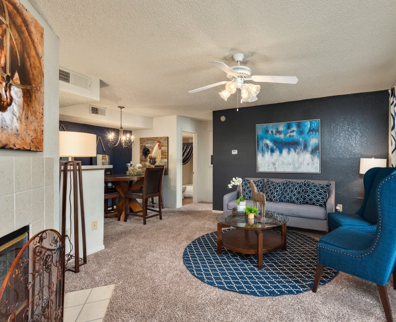 Well-furnished living area with plush carpeting and a ceiling fan in a model home at The Mansion in Independence, Missouri