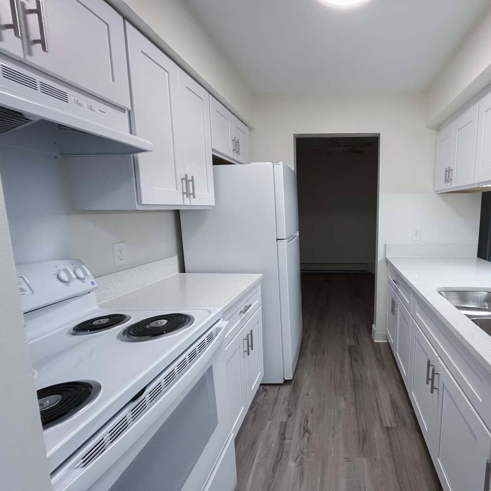 Kitchen with white shaker cabinets range and oven at Mill Pond (Brooklyn) in Brooklyn, Michigan