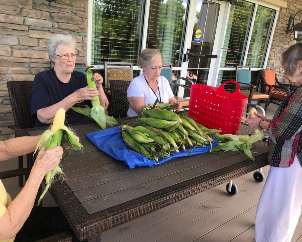 Resident shucking corn at Edencrest at The Legacy in Norwalk, Iowa.