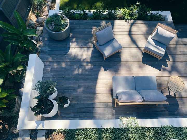 an overhead view of a backyard patio with lots of shade from surrounding trees present over the sitting area