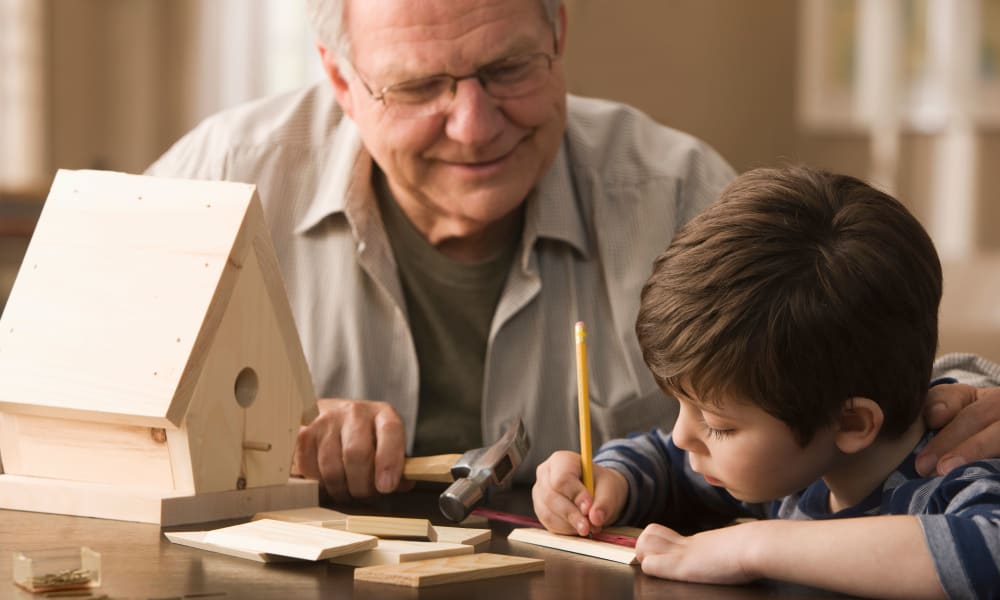 A resident and a boy building a birdhouse at Amaran Senior Living in Albuquerque, New Mexico. 