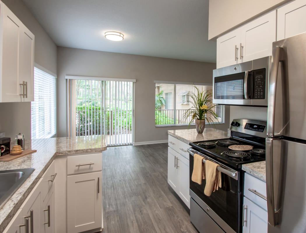 Model home kitchen showcasing hardwood floors and stainless-steel appliances at IMT Pinebrook Pointe in Margate, Florida