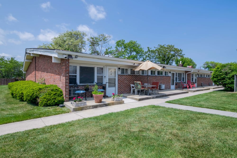 Exterior photo of an apartment with patio furniture and flowers