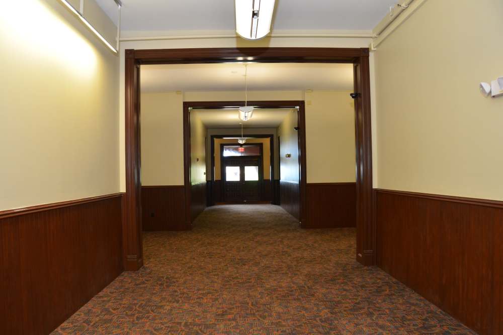Carpeted hallway with wooden accents at Bh Tapley Court in Springfield, Massachusetts