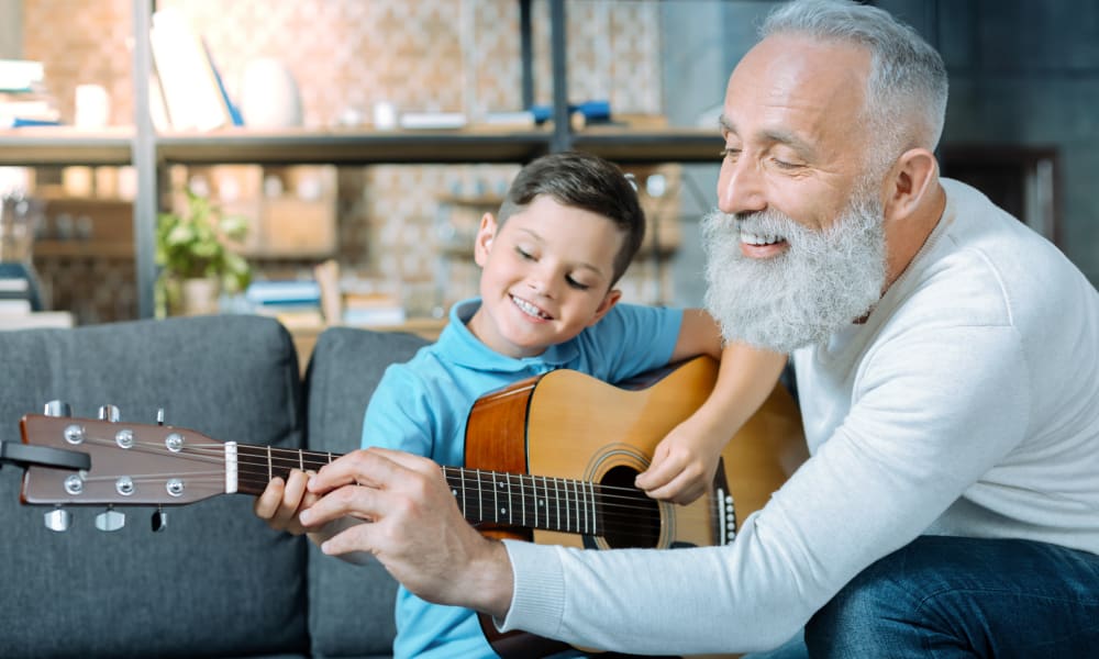 A resident and a child learning to play the guitar at Amaran Senior Living in Albuquerque, New Mexico.