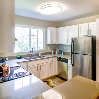 Bright kitchen with stainless-steel appliances and ample cupboard storage in a model home at Sofi at Murrayhill in Beaverton, Oregon