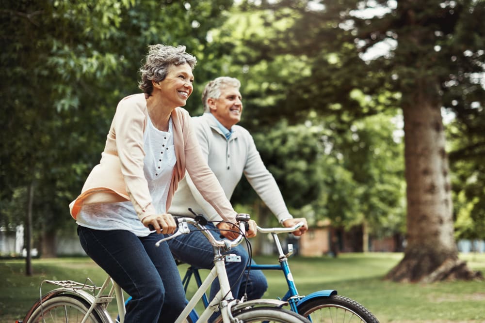 Two residents riding a bike near Merrill Gardens. 