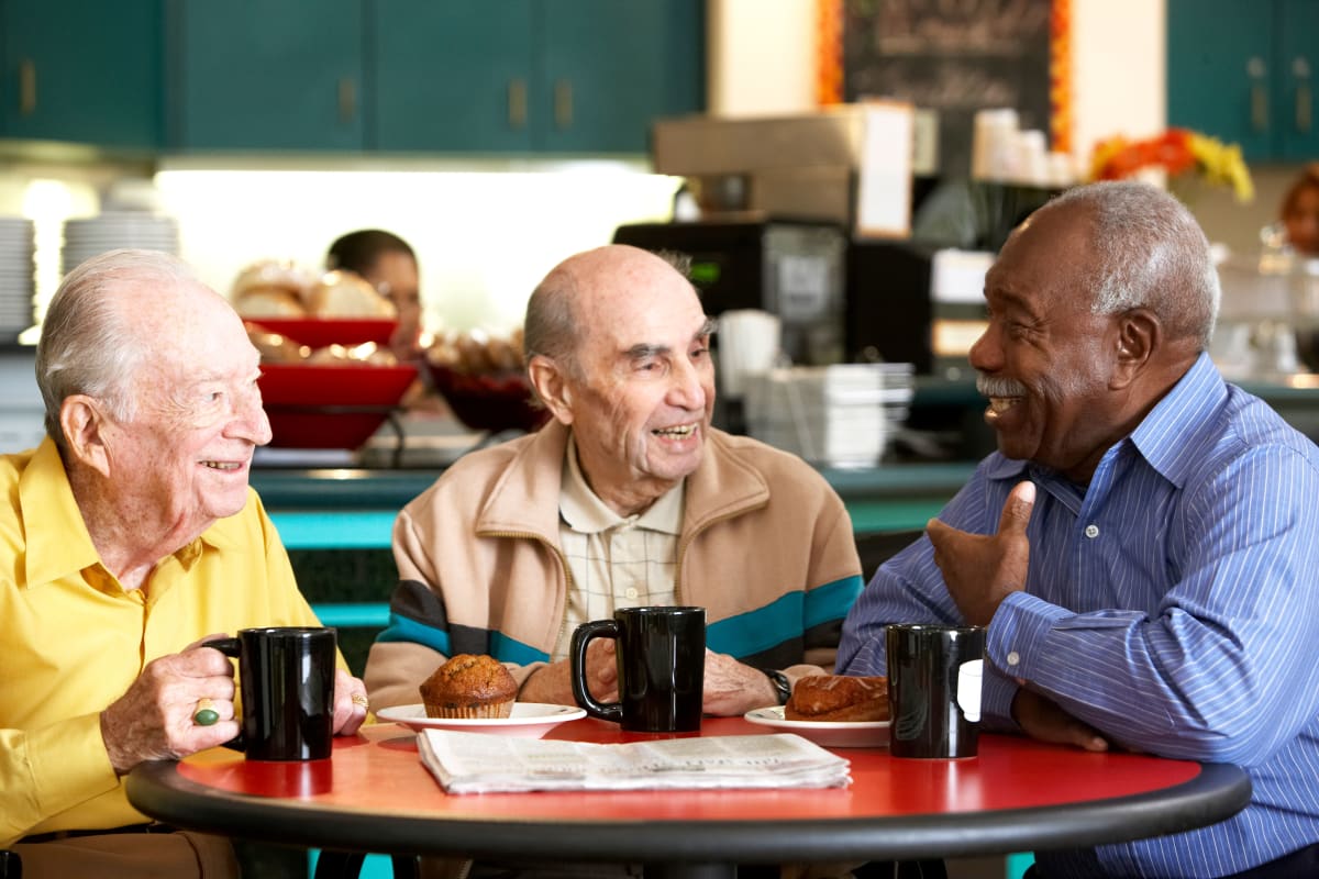 A group of residents enjoying coffee at CERTUS Premier Memory Care Living in Orange City, Florida.
