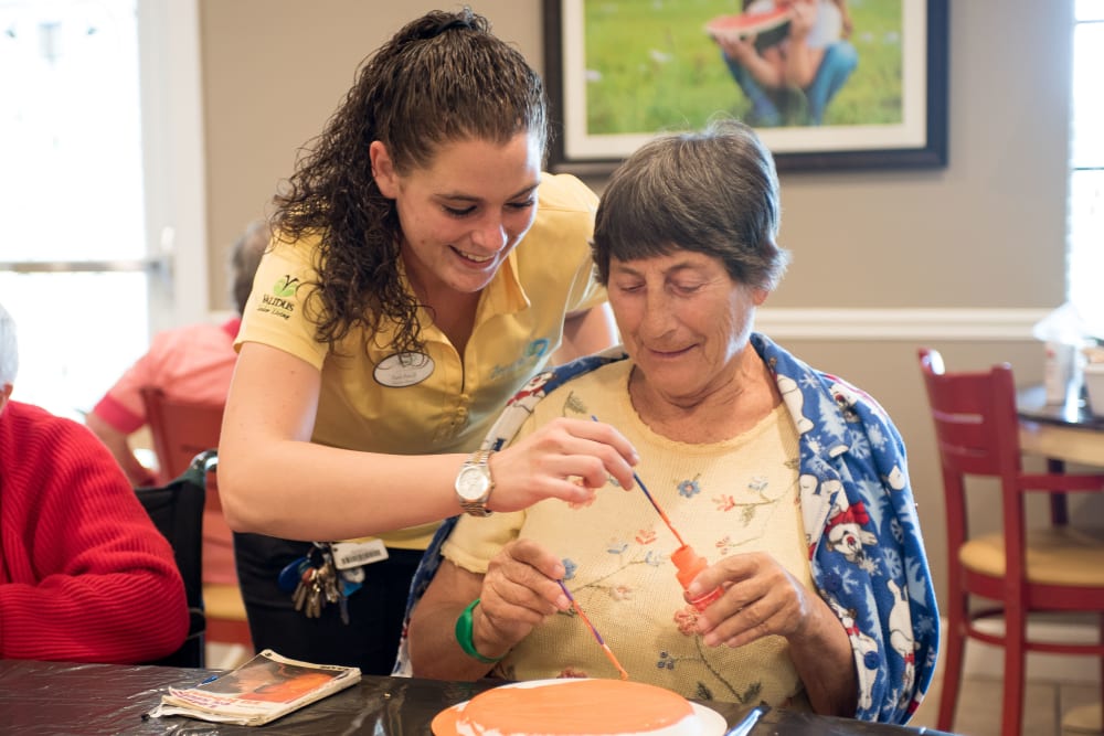 Team member and resident working on a project together at Inspired Living Bonita Springs in Bonita Springs, Florida