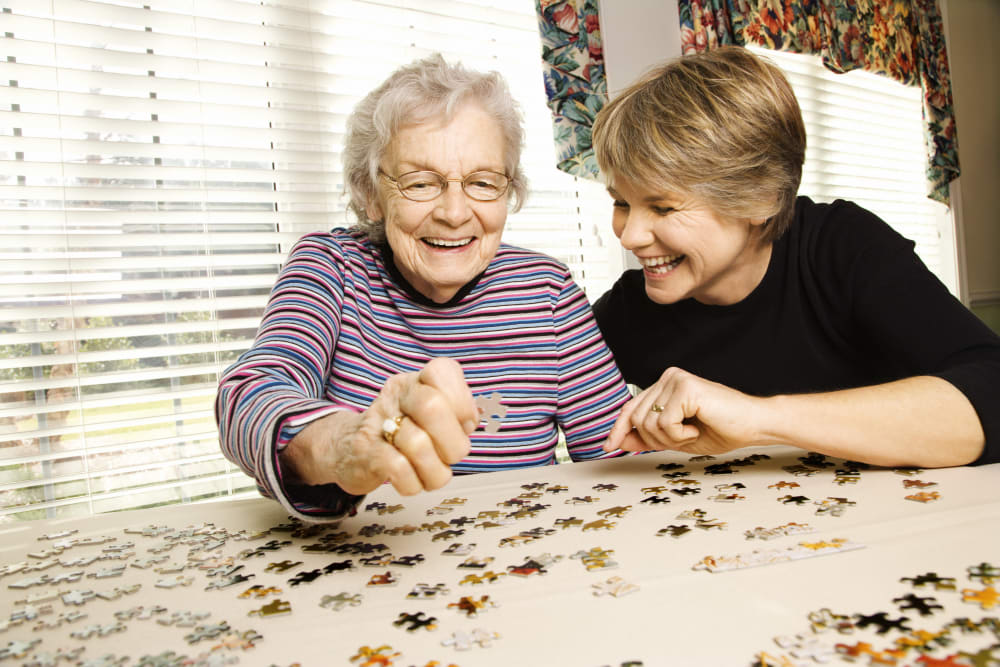 Holden of Bellevue resident doing a puzzle with a family member in her apartment in Bellevue, Washington