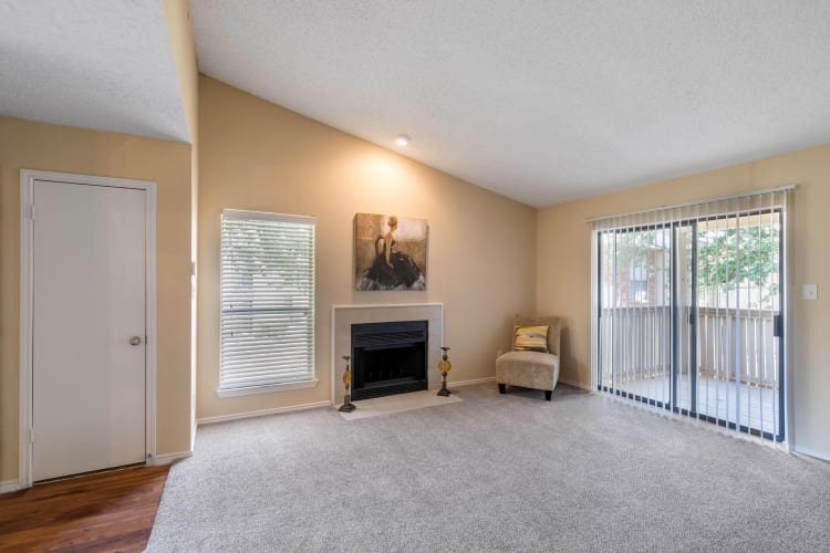 Spacious living room with a fireplace and access to a private backporch at The Logan in Bedford, Texas