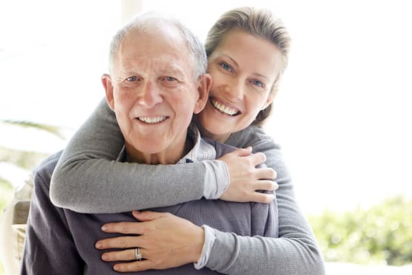 Adult child hugging father, a resident at AgeWell Living