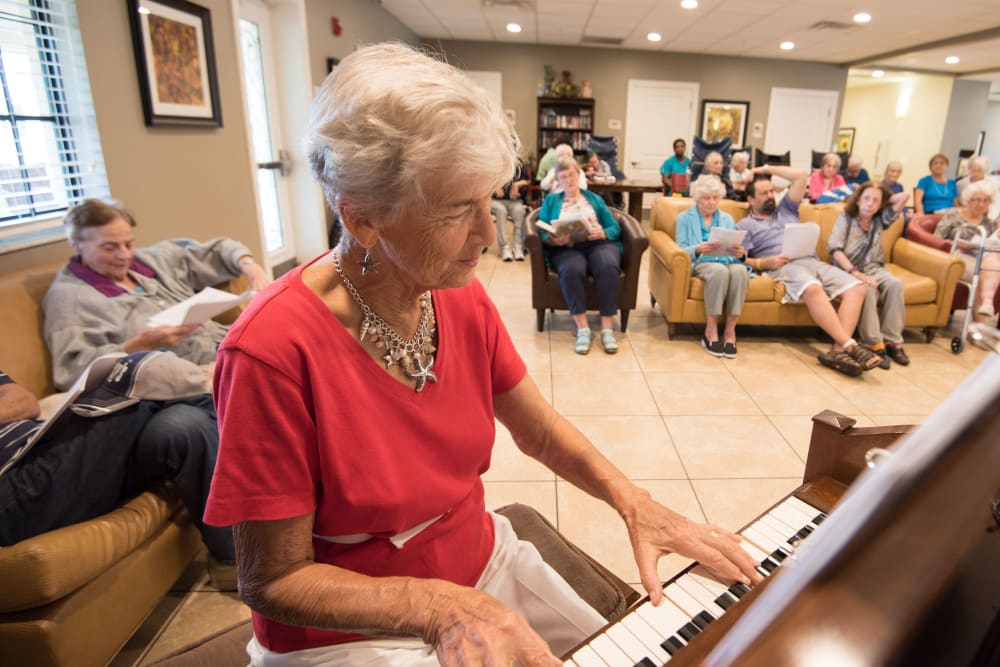 A resident playing a piano at Inspired Living Kenner in Kenner, Louisiana. 