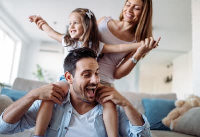 Resident mom and dad playing with their daughter before school in their apartment home at Waterfield Court Apartment Homes in Aurora, Colorado