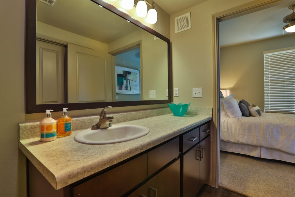 Well-lit en suite bathroom in a model home at Olympus at Waterside Estates in Richmond, Texas