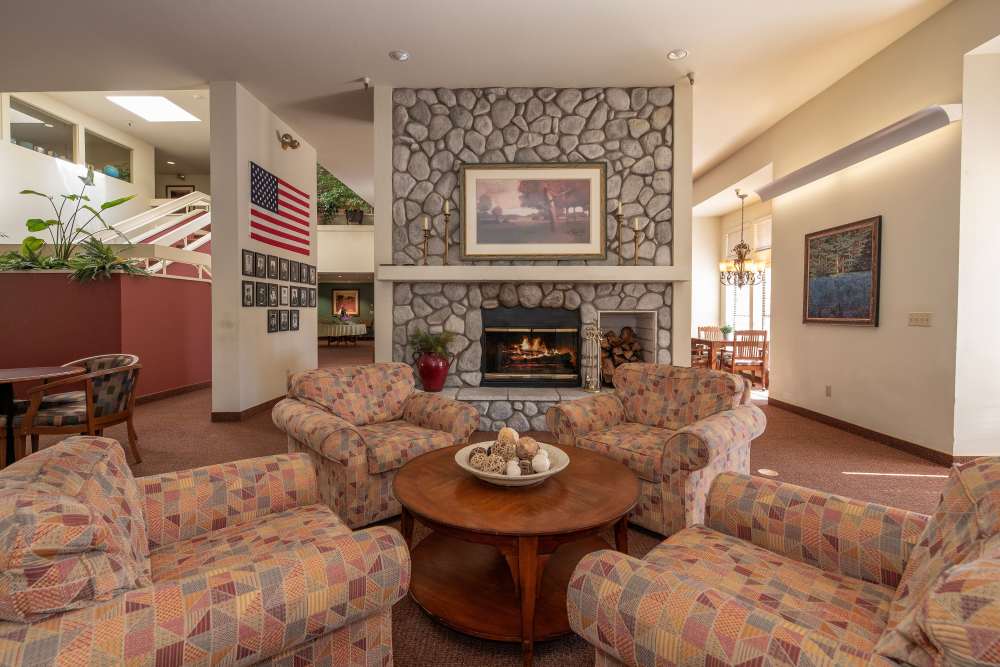 Cozy fireplace seating in the common area at Hilltop Commons Senior Living in Grass Valley, California