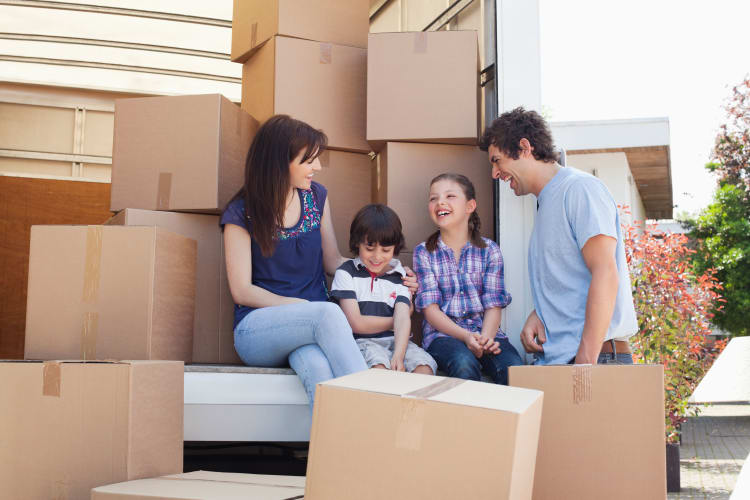 Happy family with a full moving truck ready to store their belongings at Bowman's Self Storage