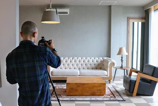 Man taking professional photos of couch to ensure it sells quickly