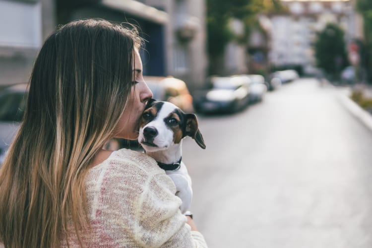 Resident giving her puppy a kiss outside their new home at Vue Fremont in Fremont, California