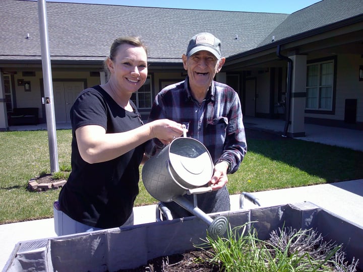 OT Lynnette helps resident of Liberty Place Memory Care with planting