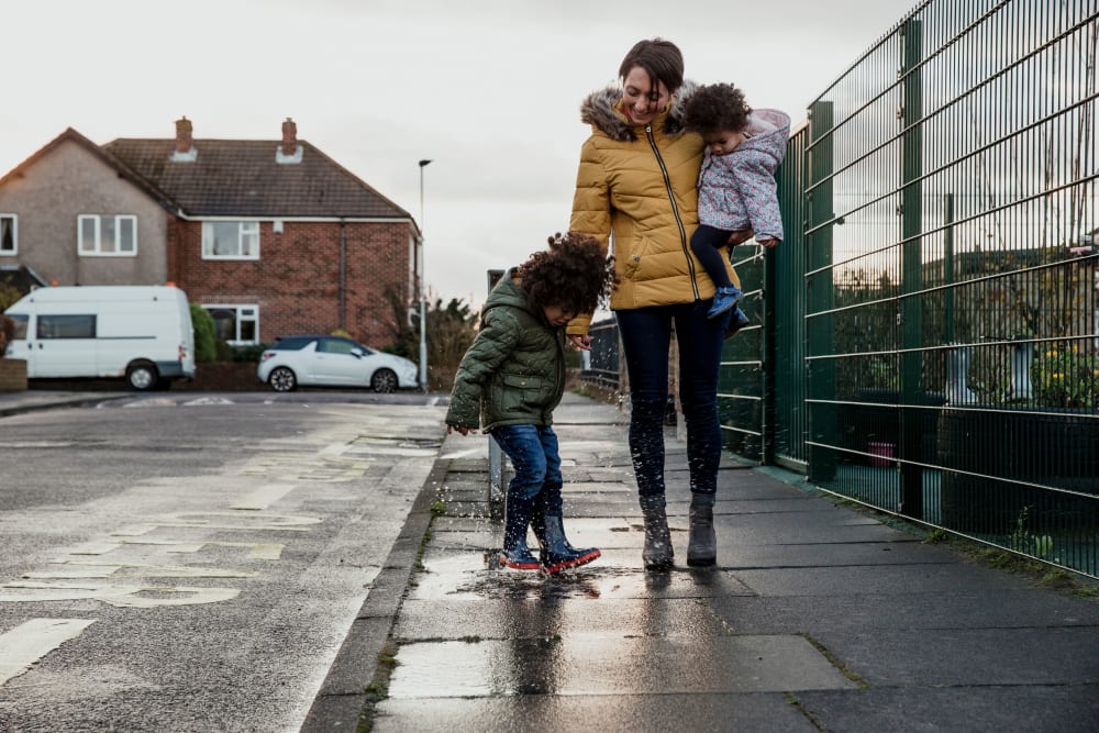 Mother walking on the sidewalk with her two kids near Riverview Gardens in Passaic, New Jersey