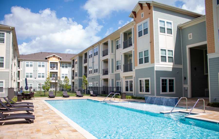 Swimming pool with exterior view of the apartment at Harmony Park in Spring, Texas