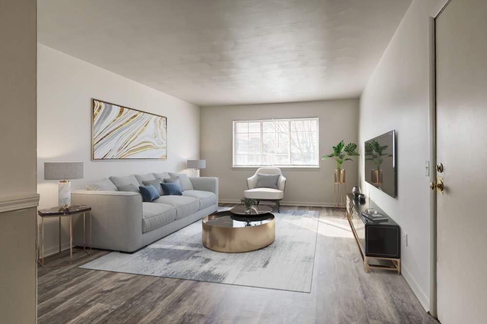 Staged living room with a large window and vinyl plank flooring at Imperial North Apartments home in Rochester, New York