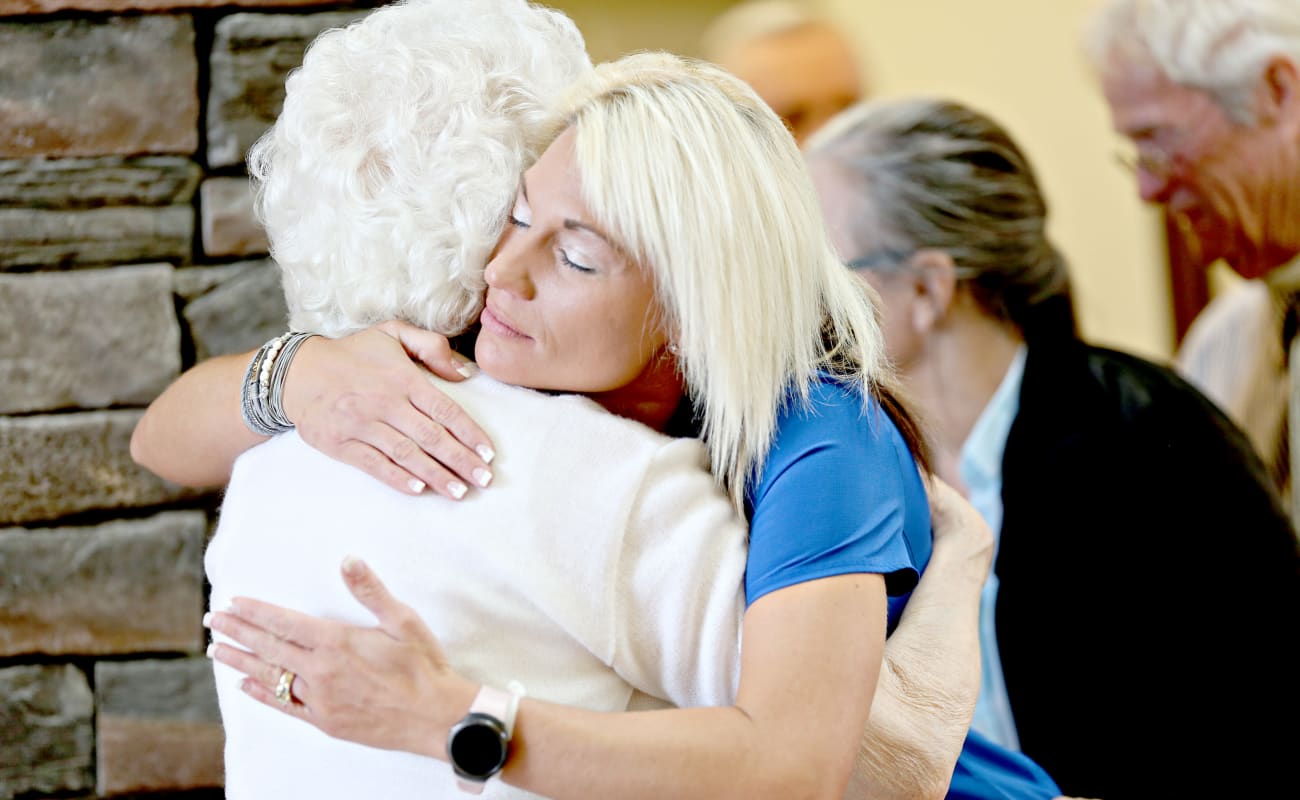 Resident and caretaker embracing in a hug at Providence Assisted Living in Clarksville, Arkansas. 