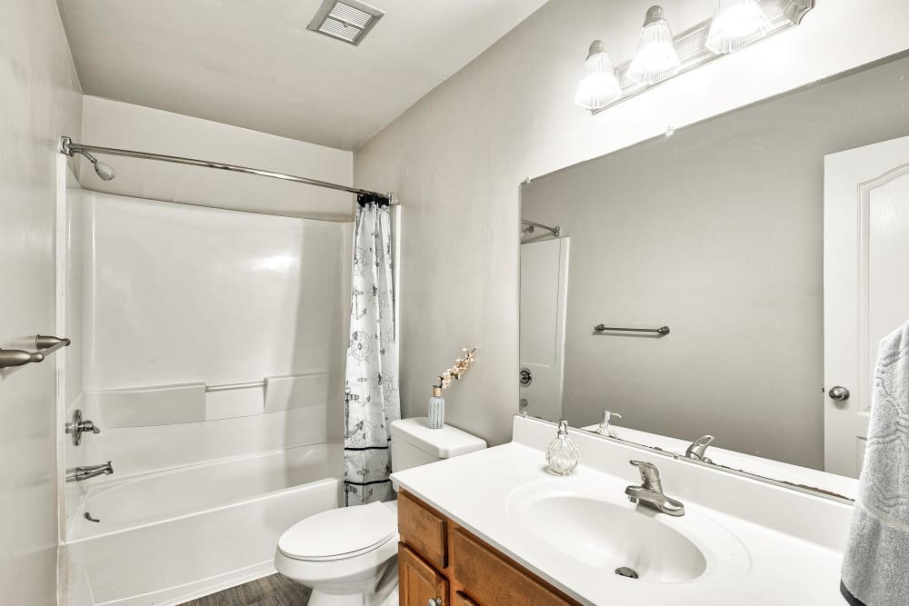 Bathroom with large vanity mirror and bathtub shower at Maple Bay Townhomes in Virginia Beach, Virginia