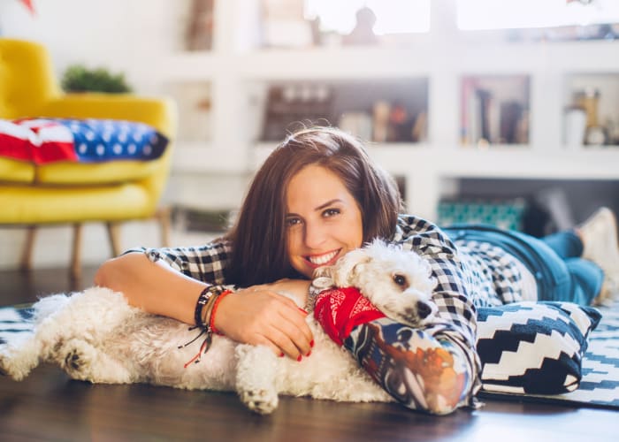 Resident enjoying her new home with dog at Crescent Apartments in Marina, California