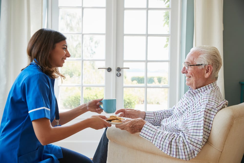 Staff brings resident a snack at Country Manor Memory Care in Davenport, Iowa.