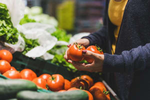 A woman picking out fresh produce in a farmers market near Mariposa at Clear Creek in Webster, Texas